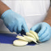 Chef in Blue Nitrile Gloves Cutting White Onions on Blue Cutting Board
